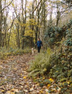 Woman hiking trail with dog to improving her mental health