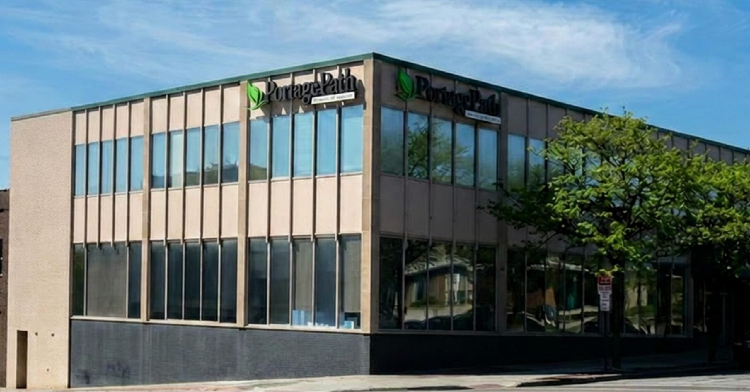 Akron Outpatient Exterior Without Tilt | Portage Path Behavioral Health Office building with large glass windows and a green leaf logo reading portage path on the facade.