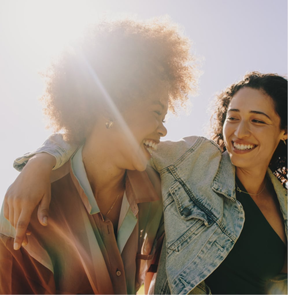 Hero-image3 - Portage Path Behavioral Health Two women laughing together outdoors, illustrating joy and a supportive path to recovery.
