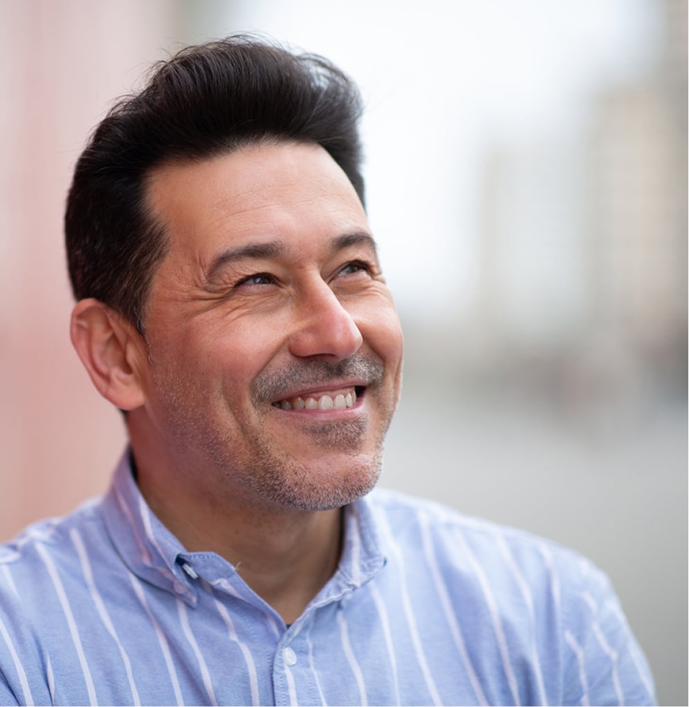 Hero-image4 - Portage Path Behavioral Health A man smiling and looking upward thoughtfully, reflecting hope and positive mental health progress.